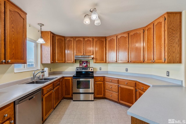 kitchen featuring appliances with stainless steel finishes, hanging light fixtures, and sink