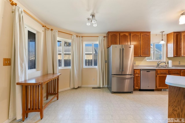 kitchen with hanging light fixtures, stainless steel appliances, and sink