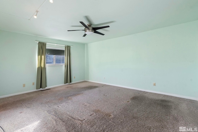 carpeted empty room with track lighting and ceiling fan