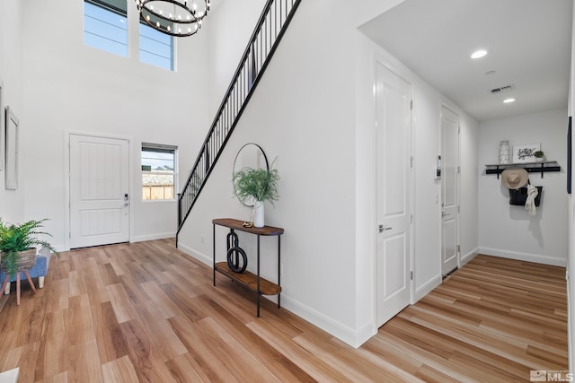 entryway featuring light wood-type flooring and an inviting chandelier