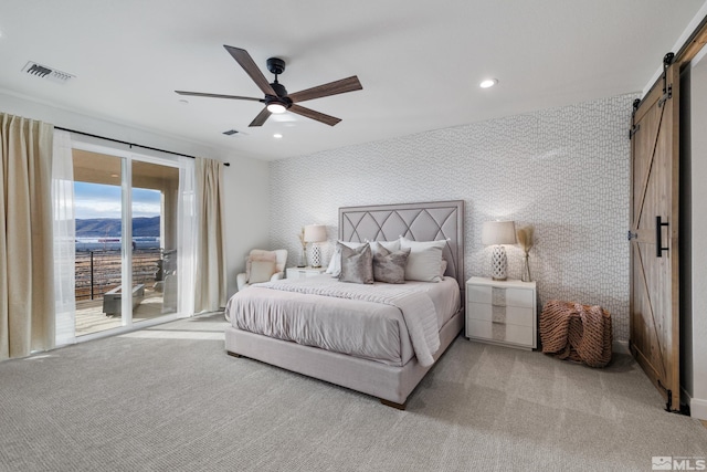 bedroom with access to outside, a barn door, ceiling fan, and light colored carpet