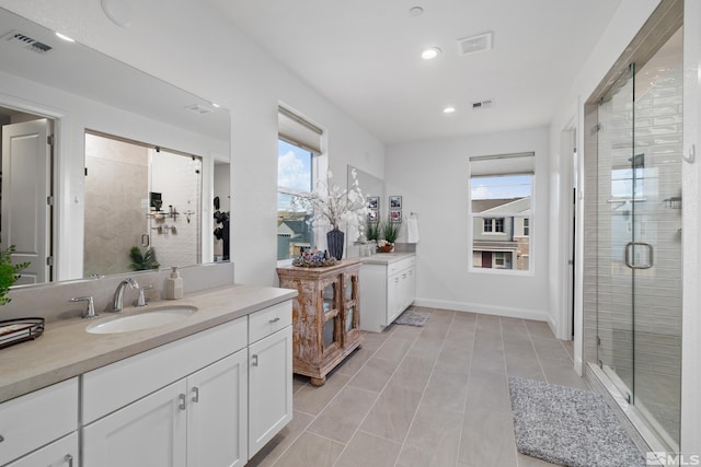 bathroom featuring tile patterned flooring, vanity, and a shower with shower door