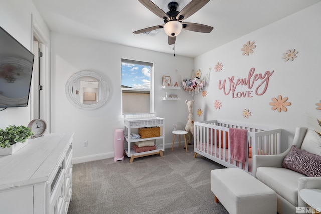 bedroom with a crib, carpet floors, and ceiling fan