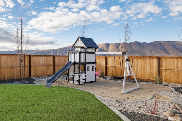 view of jungle gym featuring a mountain view and a lawn