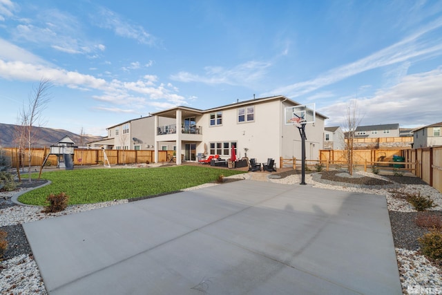 back of property featuring a lawn, basketball court, and a playground