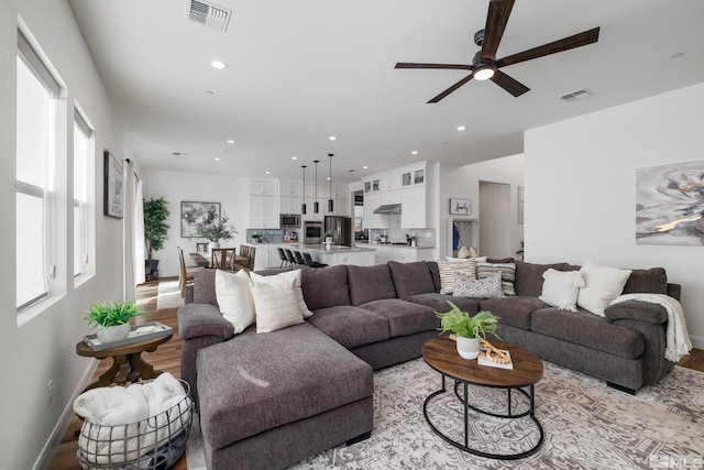 living room featuring light hardwood / wood-style floors and ceiling fan