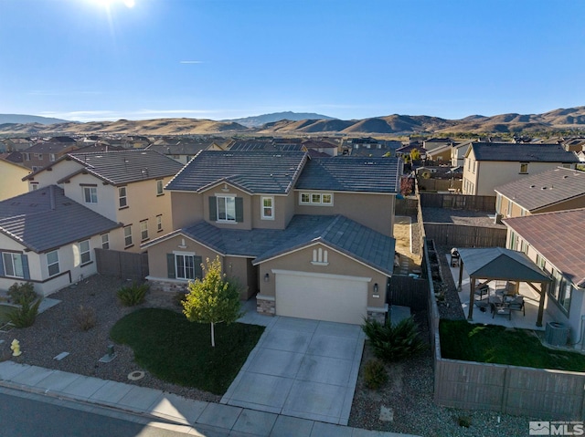 view of front of house featuring a mountain view, central AC unit, and a garage