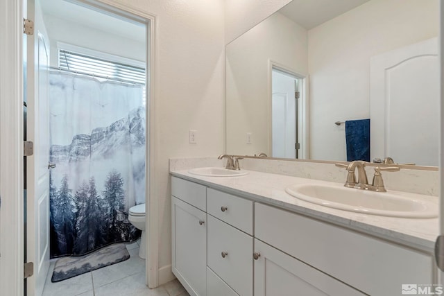 bathroom with tile patterned floors, vanity, toilet, and walk in shower