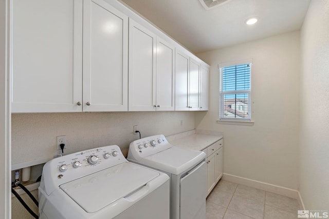 washroom with washer and dryer, cabinets, and light tile patterned floors