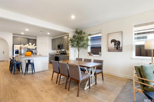 dining space with sink and light hardwood / wood-style floors