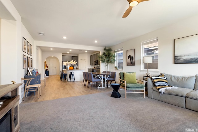 living room with light colored carpet and ceiling fan