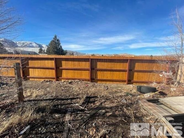 view of yard with fence and a mountain view