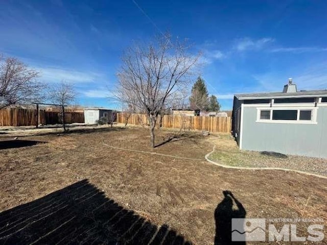 view of yard featuring a fenced backyard and an outbuilding