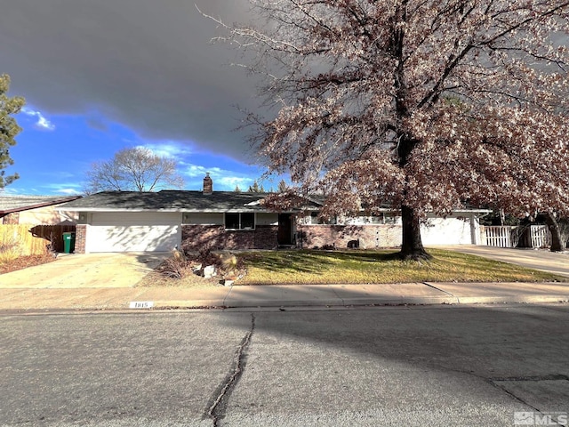 ranch-style house featuring a garage and a front lawn