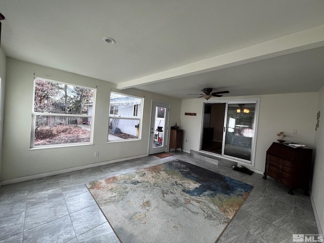 interior space with beam ceiling and ceiling fan