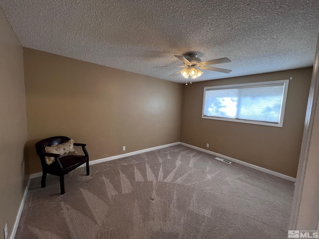 carpeted empty room with a textured ceiling and ceiling fan