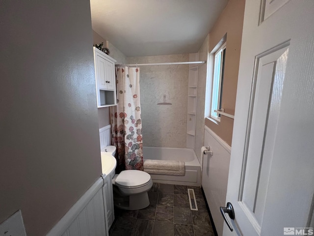 bathroom with toilet and shower / bath combo with shower curtain