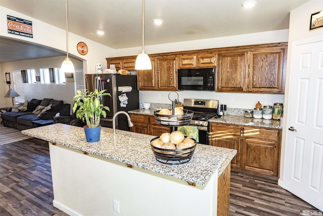 kitchen featuring stainless steel appliances, light stone counters, pendant lighting, and dark hardwood / wood-style flooring