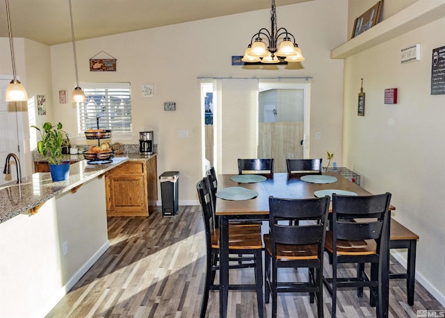 dining area featuring sink, an inviting chandelier, dark hardwood / wood-style flooring, and lofted ceiling