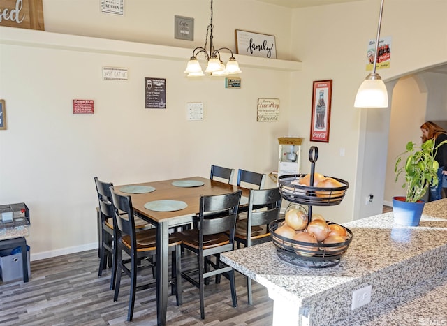 dining space with hardwood / wood-style flooring and a chandelier