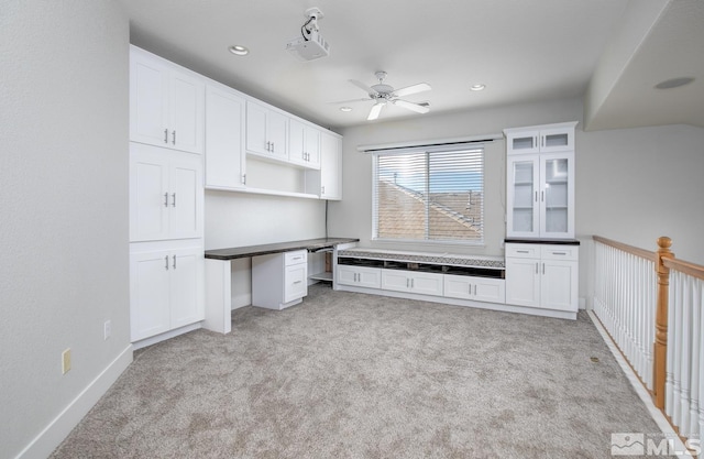 unfurnished office with ceiling fan and light colored carpet