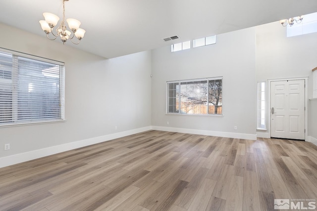 entryway with light hardwood / wood-style flooring and a chandelier