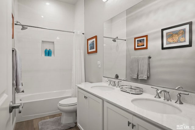 full bathroom with hardwood / wood-style floors, vanity, toilet, and shower / tub combo