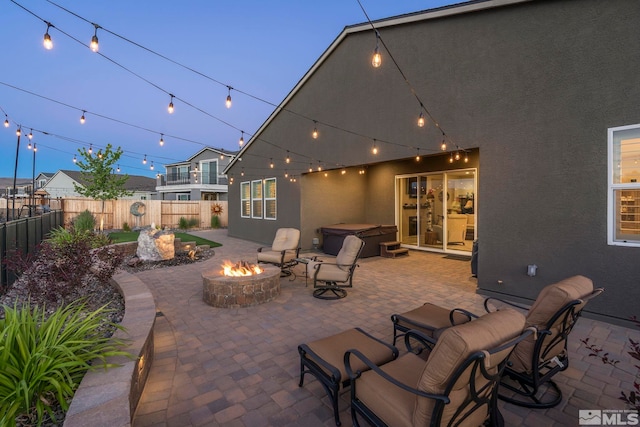 view of patio / terrace with a hot tub and a fire pit