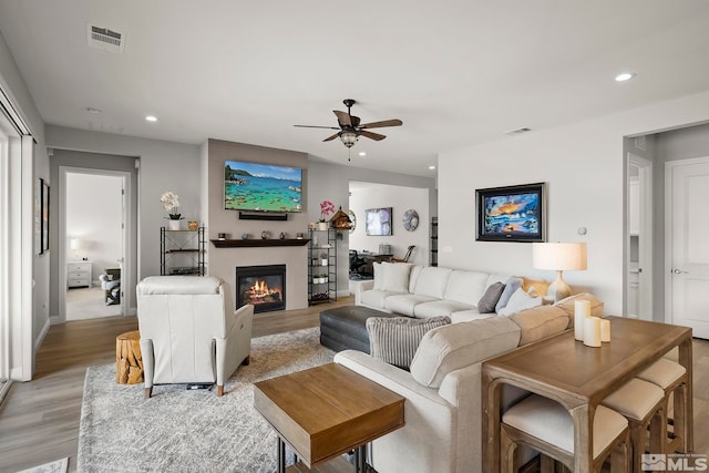 living room featuring ceiling fan and light hardwood / wood-style floors