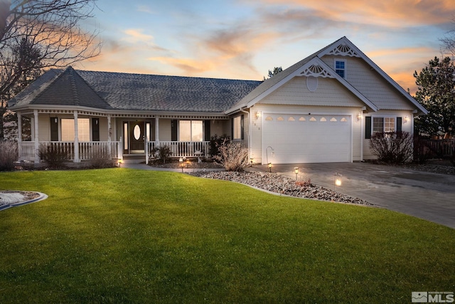 view of front of house featuring a lawn, covered porch, and a garage