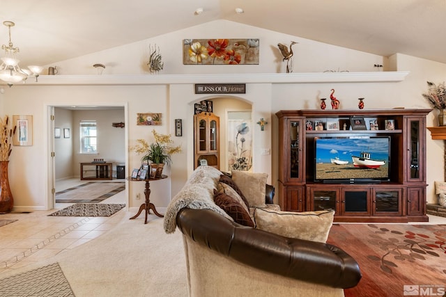 living room with light tile patterned floors, lofted ceiling, and a notable chandelier