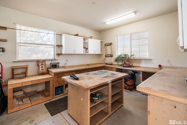 kitchen with butcher block counters and white cabinetry