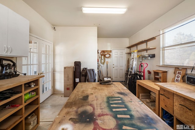 interior space with a workshop area and french doors