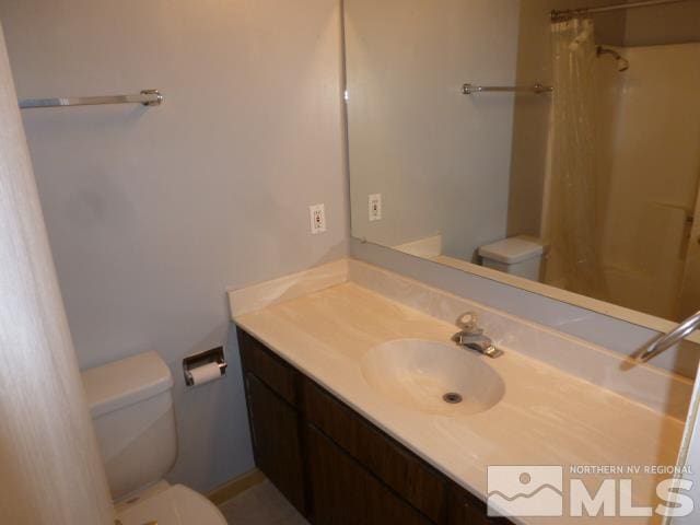 bathroom with toilet, vanity, and walk in shower