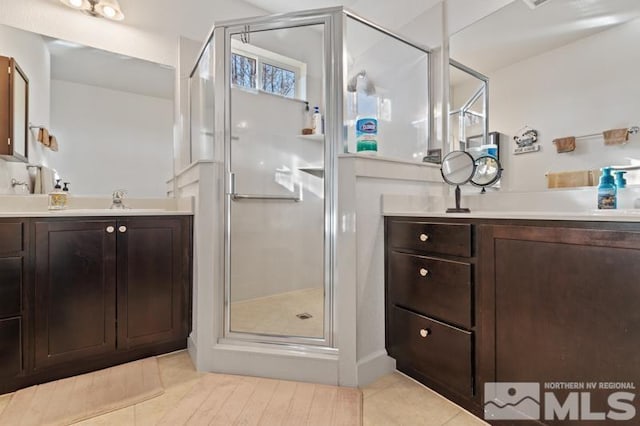 bathroom with tile patterned floors, vanity, and a shower with door