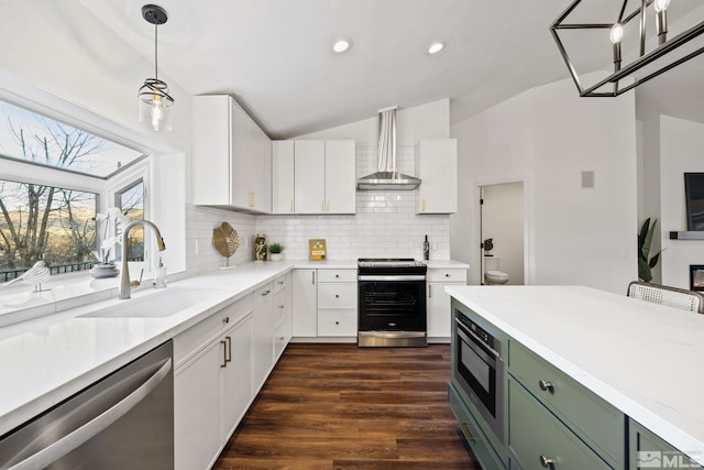 kitchen featuring sink, stainless steel appliances, wall chimney range hood, green cabinets, and white cabinets