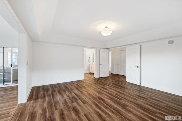 unfurnished bedroom with dark hardwood / wood-style flooring and ensuite bath