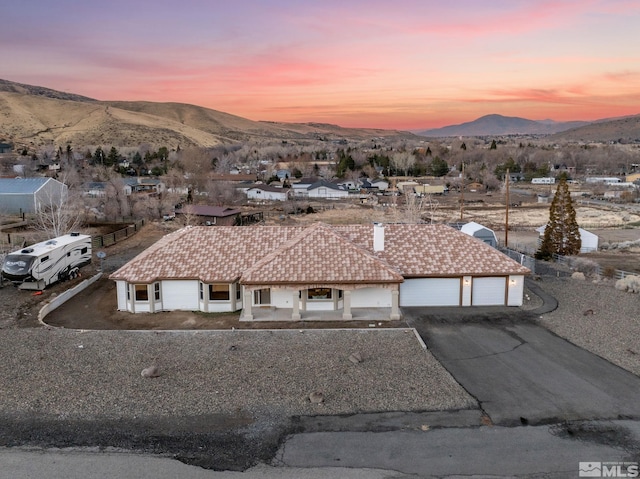 aerial view at dusk featuring a mountain view