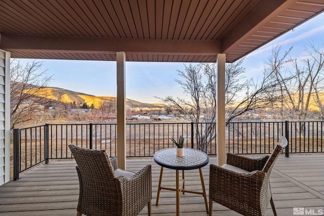 deck at dusk featuring a mountain view