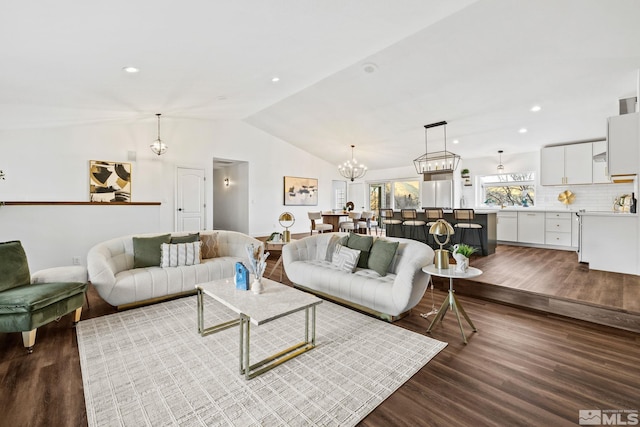 living room with dark hardwood / wood-style floors, lofted ceiling, and a notable chandelier