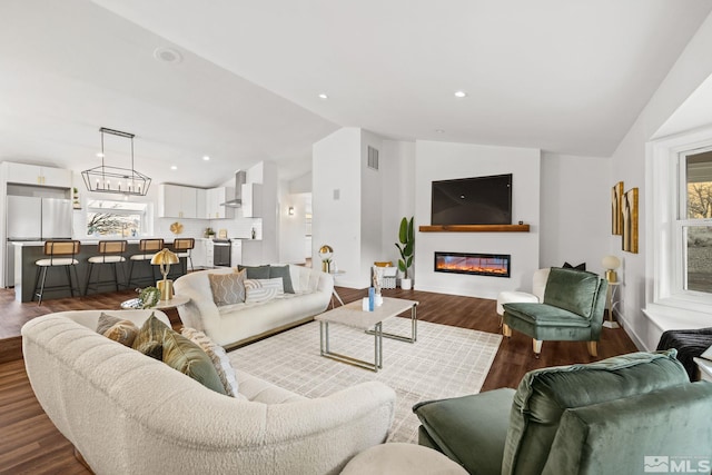 living room with wood-type flooring, lofted ceiling, and a notable chandelier