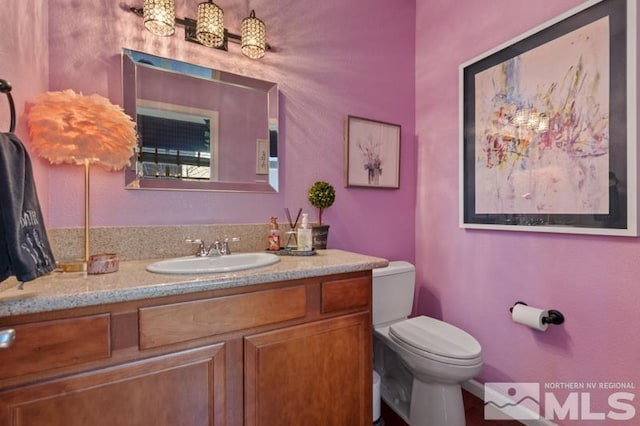 bathroom featuring vanity and toilet