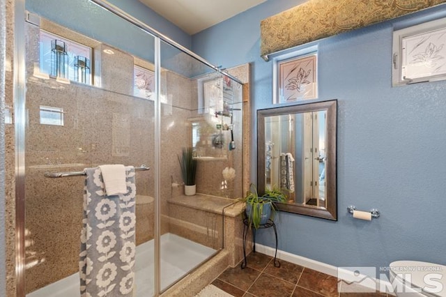 bathroom featuring tile patterned floors, an enclosed shower, and toilet