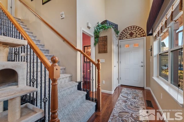 foyer featuring dark hardwood / wood-style floors and a high ceiling