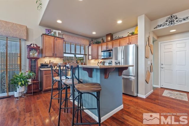 kitchen featuring a wealth of natural light, a kitchen island, a breakfast bar area, and appliances with stainless steel finishes