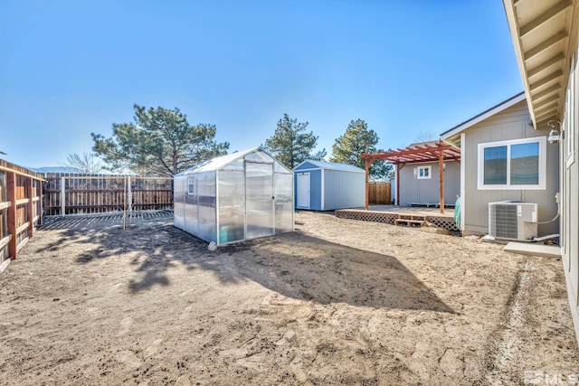 view of yard featuring an outbuilding, a pergola, a deck, and central AC