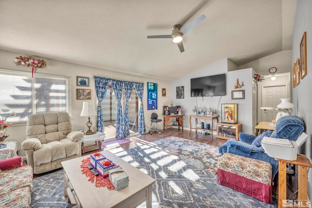 living room with ceiling fan, hardwood / wood-style floors, and vaulted ceiling