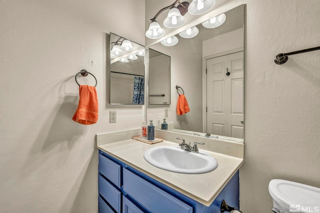 bathroom featuring vanity and toilet