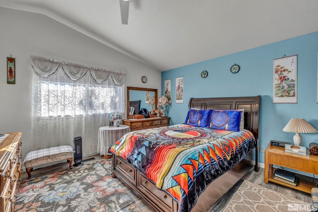 bedroom with ceiling fan, vaulted ceiling, and hardwood / wood-style flooring