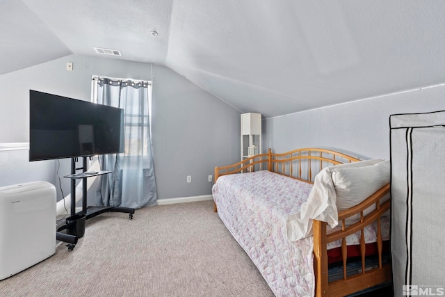 carpeted bedroom with lofted ceiling and a textured ceiling